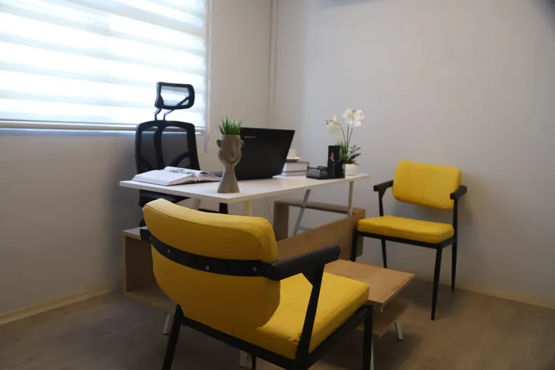 Pax Office hazır ofisinde çalışma masası ve sarı ziyaretçi koltukları